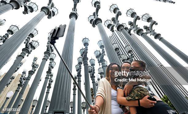 Marjorie Mabini takes a "selfie" with her niece Jaydah Mabini, and son Jaren in front of the "Urban Light" lampost installation at the Los Angeles...