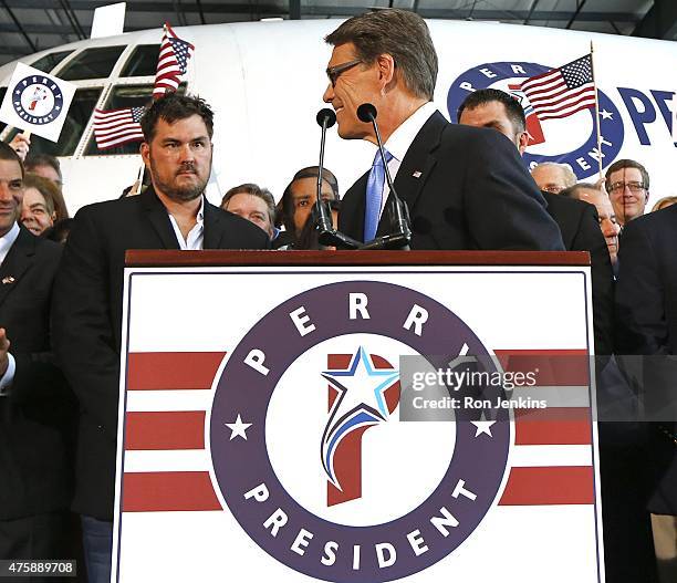 Former Texas Governor Rick Perry takes the stage as supporters including retired U.S. Navy SEAL and author of the book "Lone Survivor" Marcus...