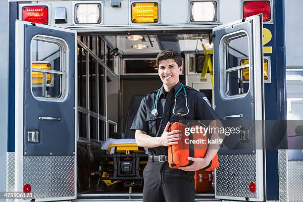 paramedic standing by ambulance - paramedic stock pictures, royalty-free photos & images