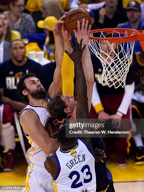 Timofey Mozgov of the Cleveland Cavaliers dunks against Andrew Bogut and Draymond Green of the Golden State Warriors in the first quarter during Game...