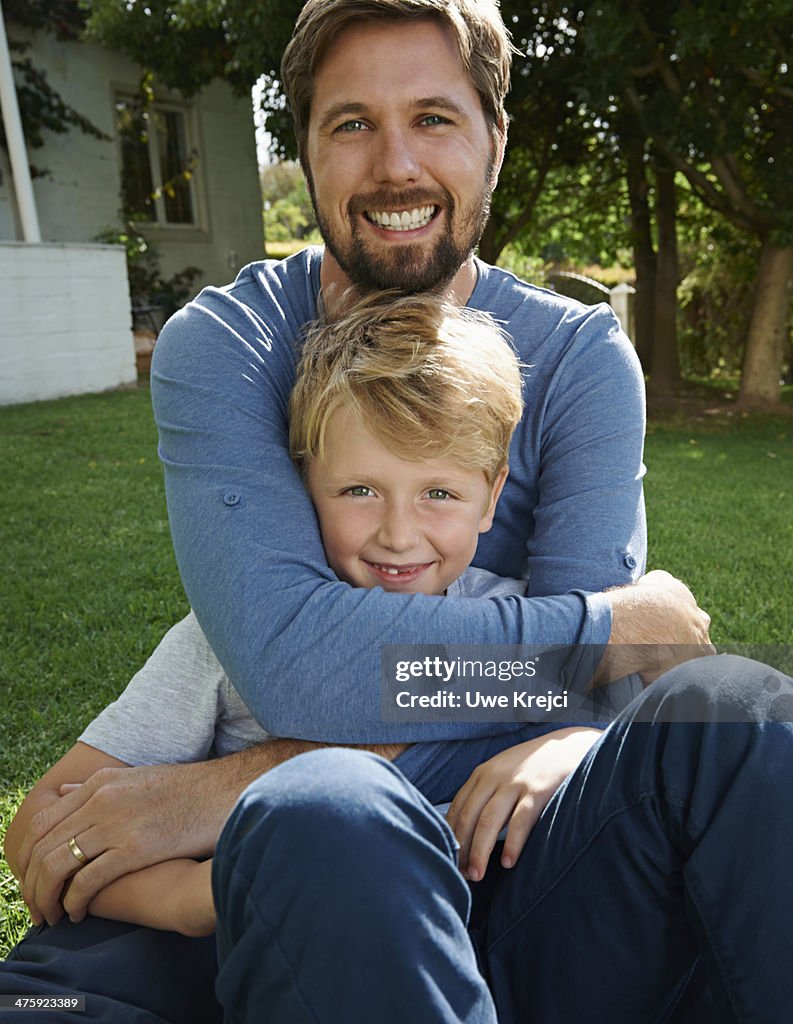 Father hugging his son, outdoors, portrait