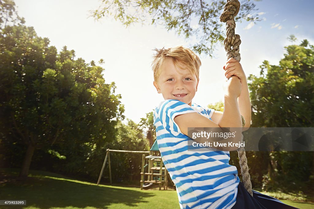 Boy on zip line swing, smiling