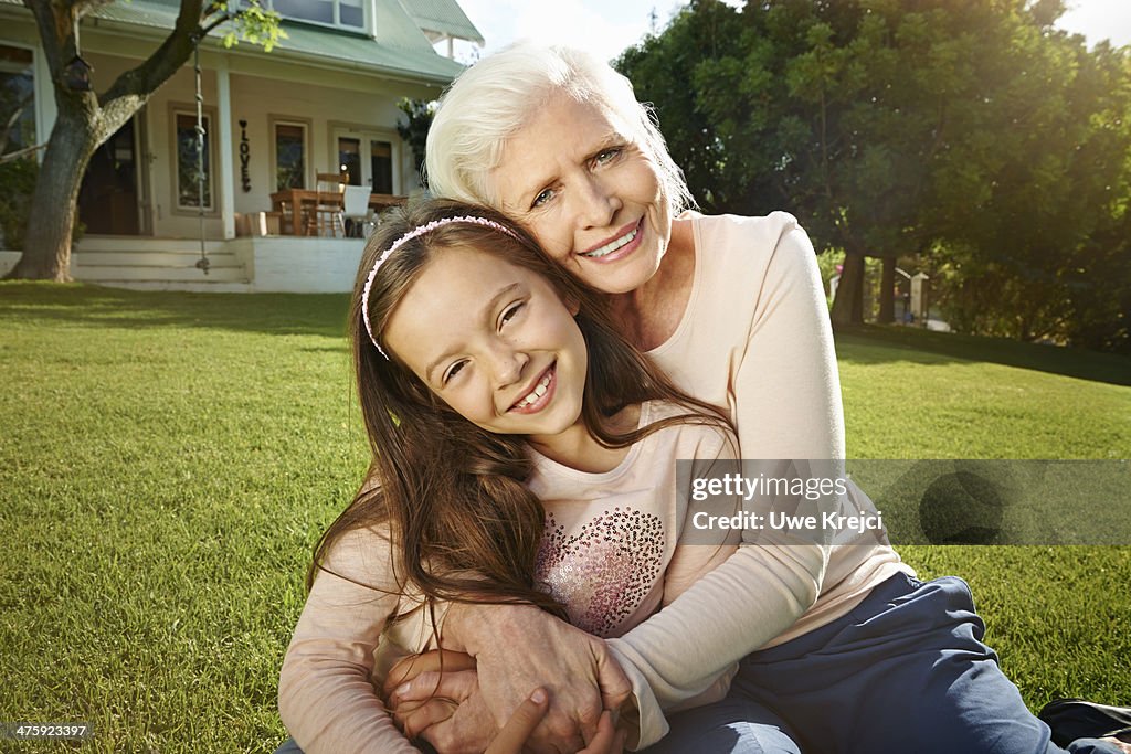 Senior woman and young girl embracing outdoors