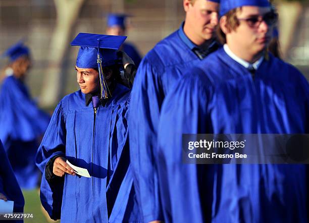 Christian Titman, left, adjusts his feather as he and classmates prepare to enter Clovis High's Lamonica Stadium on Wednesday, June 4 in Clovis,...