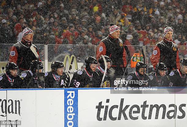 Assistant Coach Mike Kitchen, Head Coach Joel Quenneville and Assistan Coach Jamie Kompon of the Chicago Blackhawks look on from the bench area...