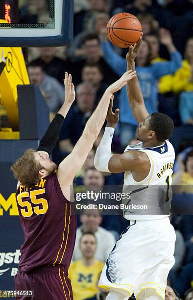 Glenn Robinson III of the Michigan Wolverines takes a shot against Elliott Eliason of the Minnesota Golden Gophers during the second half of a game...