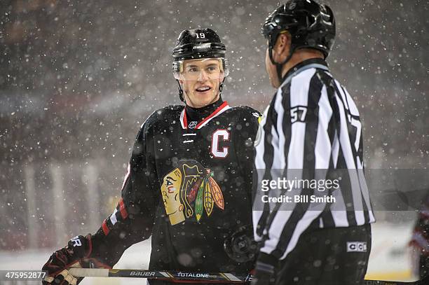 Jonathan Toews of the Chicago Blackhawks talks with linesman Jay Sharrers during the 2014 NHL Stadium Series against the Pittsburgh Penguins on March...