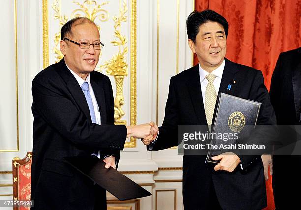 Philippine President Benigno Aquino and Japanese Prime Minister Shinzo Abe shake hands during a joint press conference after their meeting at the...