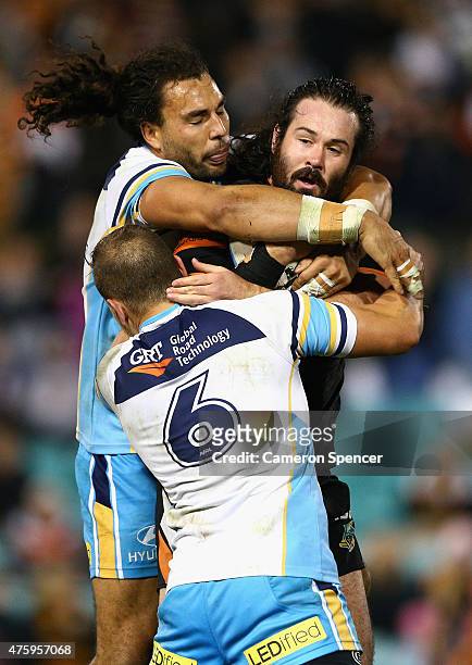 Aaron Woods of the Tigers is tackled during the round 13 NRL match between the Wests Tigers and the Gold Coast Titans at Leichhardt Oval on June 5,...