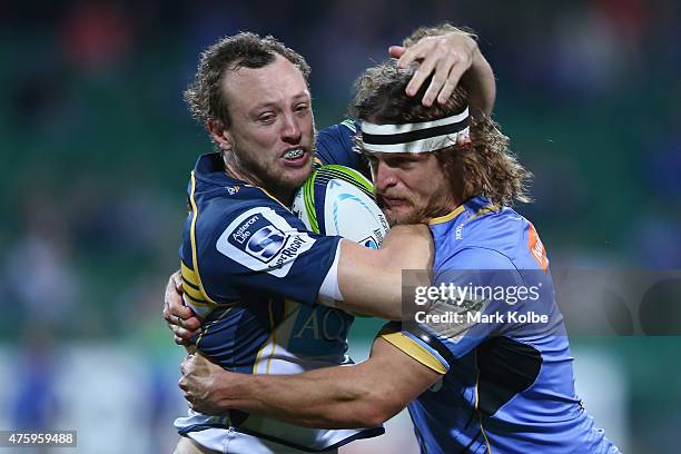 Jessie Mogg of the Brumbies is tackled by Nick Cummins of the Force during the round 17 Super Rugby match between the Western Force and the Brumbies...