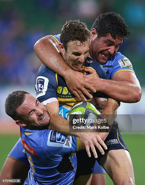 Luke Morahan and Pekahou Cowan of the Force tackle Nic White of the Brumbies during the round 17 Super Rugby match between the Western Force and the...