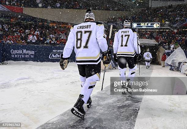 Sidney Crosby and Taylor Pyatt of the Pittsburgh Penguins walk back to the locker room after warm-up prior to the 2014 NHL Stadium Series game at...