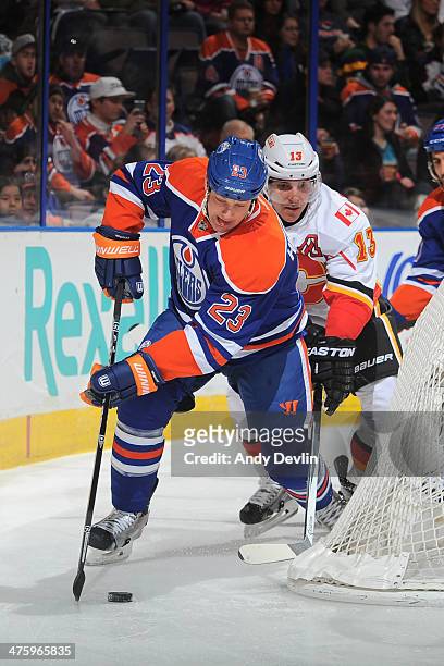 Matt Hendricks of the Edmonton Oilers skates with the puck while being pursued by Mike Cammalleri of the Calgary Flames on March 1, 2014 at Rexall...