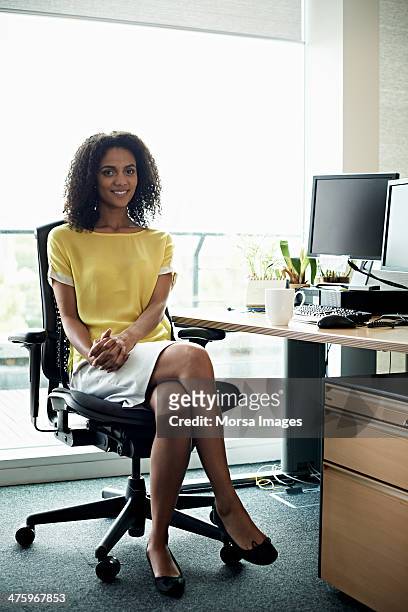 portrait of smiling businesswoman - legs crossed at knee stock pictures, royalty-free photos & images