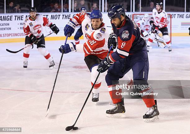 Frazer McLaren of Canada and Nedeljko Lukacevic of the United States of America compete for the puck during the 2015 Ice Hockey Classic match between...