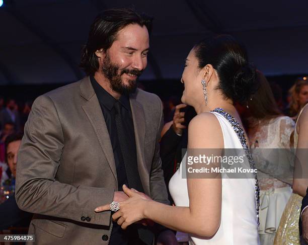 Actors Keanu Reeves and Li Gong, wearing Piaget, attend the 2014 Film Independent Spirit Awards at Santa Monica Beach on March 1, 2014 in Santa...