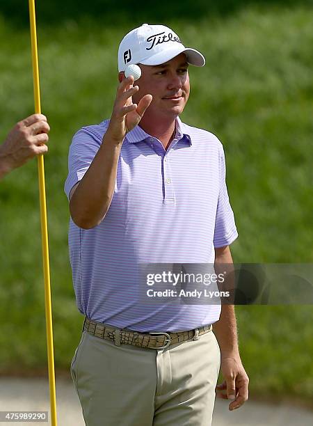 Jason Dufner waves to the gallery after making a hole in one on the 16th hole during the second round of The Memorial Tournament presented by...