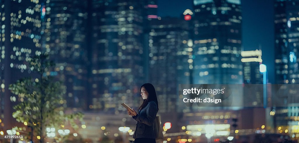 Pretty office lady is using tablet in city