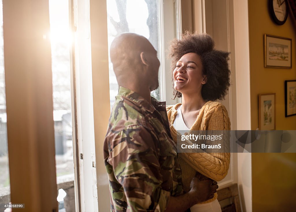 Alegre afroamericana mujer hablando con su marido militar.