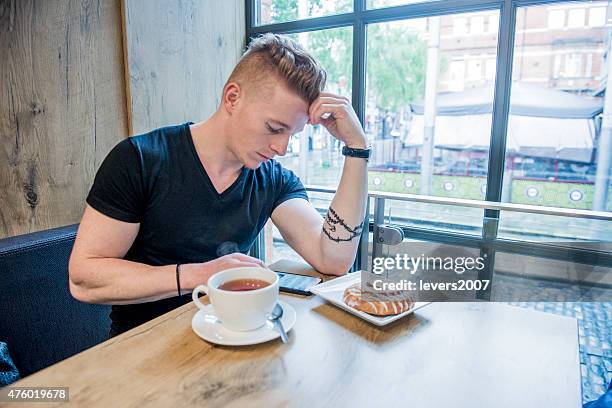 handsome young man on his phone in cafe - irish redhead stock pictures, royalty-free photos & images