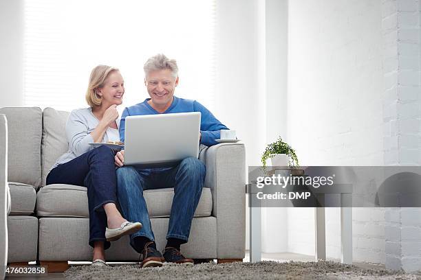 cheerful mature couple using laptop computer at home - real wife sharing 個照片及圖片檔