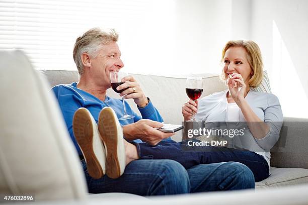 happy mature couple  watching  television at home - 50 watching video stock pictures, royalty-free photos & images