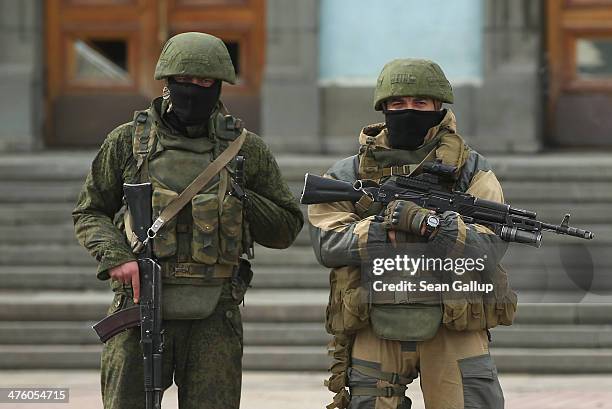 Heavily-armed troops displaying no identifying insignia and who were mingling with local pro-Russian militants stand guard outside a local government...