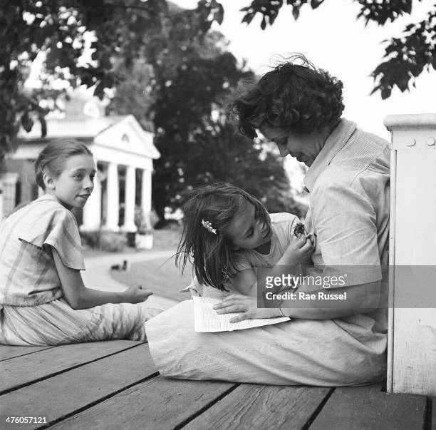 Woman and her family sit on a porch on the grounds of Thomas Jefferson's plantation, Monticello, Charlottesville, Virginia, 1949.
