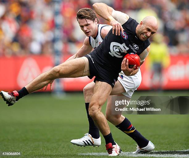 Chris Judd of the Blues lands awkwardly after marking ahead of Patrick Dangerfield of the Crows during the 2015 AFL round ten match between the...