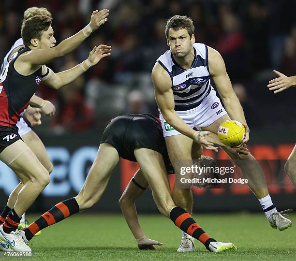 Joe Daniher of the Bombers gets his leg stuck when trying to stop Jared Rivers of the Cats during the round 10 AFL match between the Essendon Bombers...