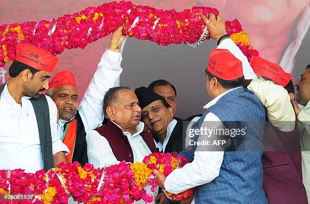 Samajwadi Party Supremo Mulayam Singh Yadav with party leader Mohammad Azam Khan is greeted with a garland by Samajwadi leaders during a public rally...