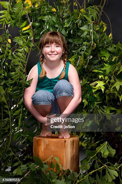 girl  surround by trees in the studio, smiling - banbossy stock pictures, royalty-free photos & images