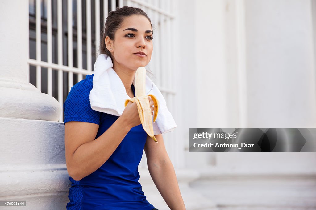 Pretty runner eating a banana