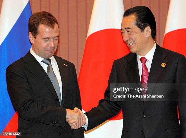 Russian President Dmitry Medvedev and Japanese Prime Minister Naoto Kan shake hands during their bilateral meeting on the sidelines of the G8 summit...