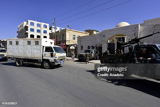 Yemeni soldiers escort a van carrying four of al-Qaeda militants accused of kidnapping a Swiss woman and murdering a Saudi diplomat in 2012, at the...