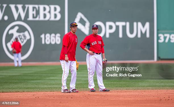 Koji Uehara of the Boston Red Sox and teammate Junichi Tazawa talk during batting practice before a game against the Oakland Athletics at Fenway Park...