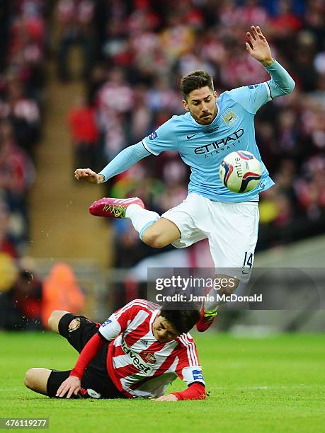 Javi Garcia of Manchester City is tackled by Ki Sung-Yueng of Sunderland during the Capital One Cup Final between Manchester City and Sunderland at...