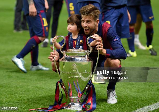 Barcelona's defender Gerard Pique and his son Milan celebrate with the trophy after the UEFA Champions League Final football match between Juventus...