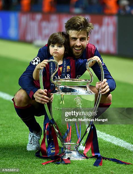 Gerard Pique of Barcelona poses with his son Milan and the trophy after the UEFA Champions League Final between Juventus and FC Barcelona at...