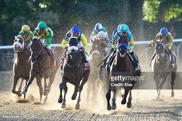 American Pharoah, ridden by Victor Espinoza, leads the field out of the fourth turn during the 147th running of the Belmont Stakes at Belmont Park on...