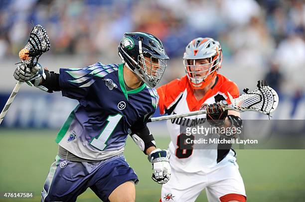 Joe Walters of the Chesapeake Bayhawks runs with the ball with pressure from Gregory Downing of the Denver Outlaws during a MLL lacrosse game at...