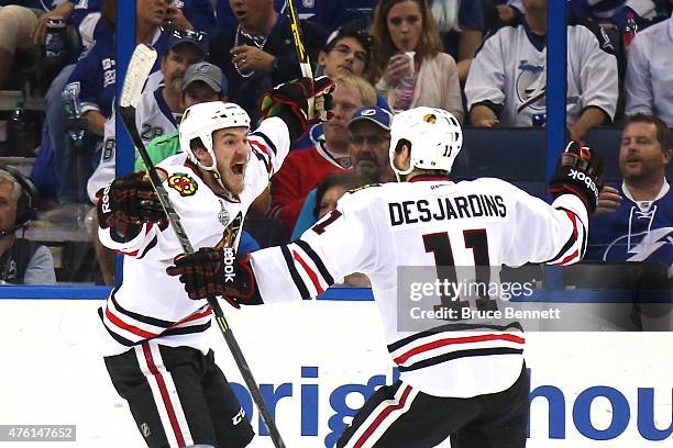 Andrew Shaw of the Chicago Blackhawks celebrates with teammate Andrew Desjardins after scoring a goal against Ben Bishop of the Tampa Bay Lightning...