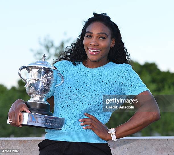 S Serena Williams poses with the winner's trophy at the Bir-Hakeim bridge after winning the women's final of the French Open tennis championships at...