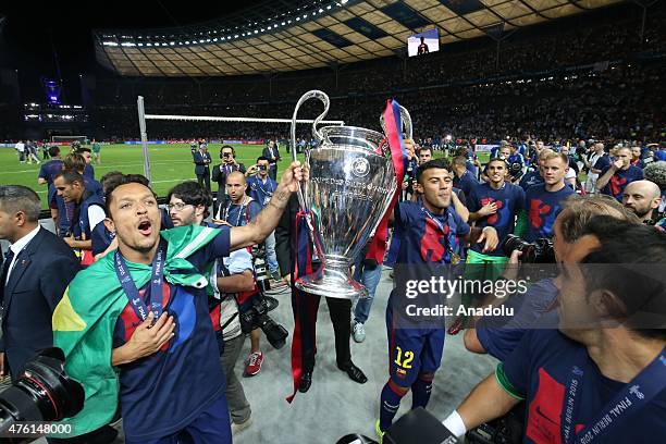 Rafinha and Adriano of FC Barcelona pose with the UEFA Champions League trophy after winning over Juventus at Olympiastadion on June 6, 2015 in...