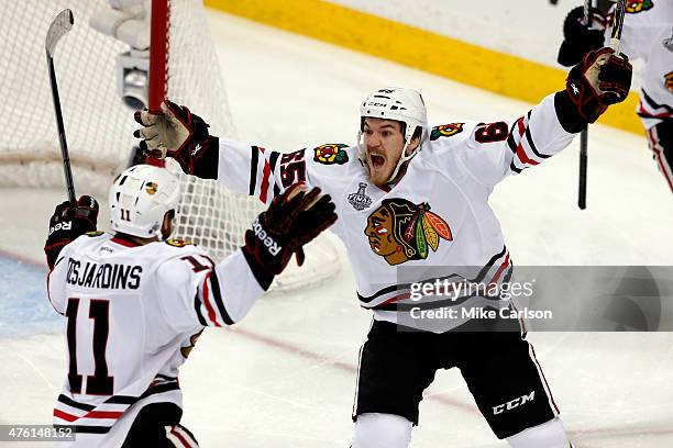 Andrew Shaw of the Chicago Blackhawks celebrates with teammate Andrew Desjardins after scoring a goal against Ben Bishop of the Tampa Bay Lightning...