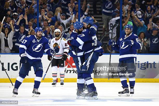 Jason Garrison of the Tampa Bay Lightning celebrates with teammate Victor Hedman after scoring a third period goal against Corey Crawford of the...