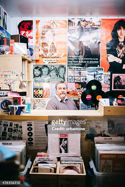 portrait, man behind checkout counter, vinyl record shop, pop music - popmuzikant stockfoto's en -beelden