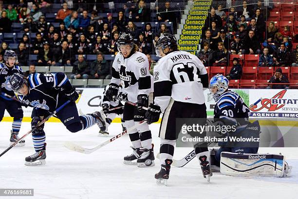 Frederic Bergeron and Danick Martel of the Blainville-Boisbriand Armada watch the rebounding puck in front of Julio Billia of the Chicoutimi...