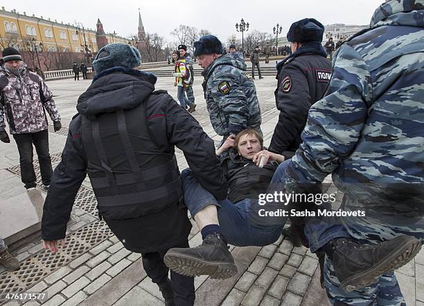Man is detained by riot police during an unsanctioned anti-war rally close to the Kremlin at Manezhnaya Square on March 2, 2014 in Moscow, Russia,...