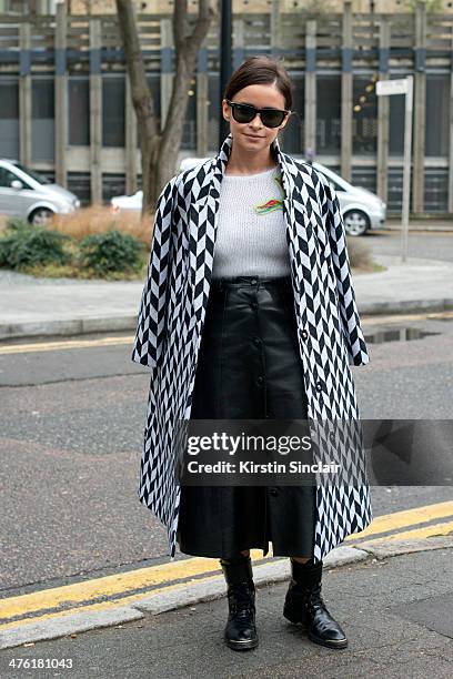 Founder of Buro247 Miroslava Duma wears a Vika Gazinskaya coat and Natasha Zinko top and skirt, Louis Vuitton boots and Ray Ban sunglasses on day 5...